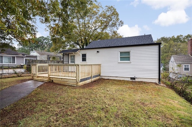 rear view of property featuring a yard and a deck