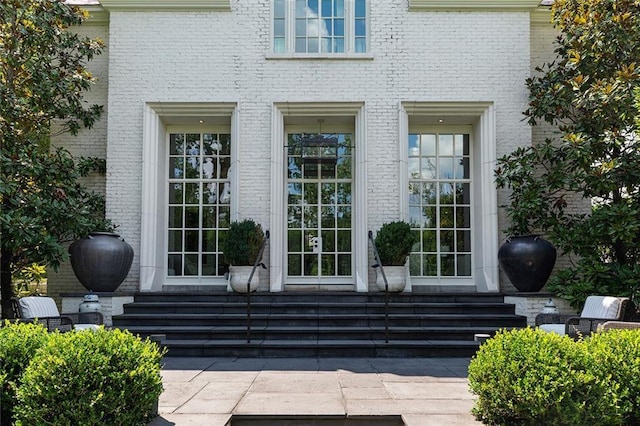 view of exterior entry featuring brick siding