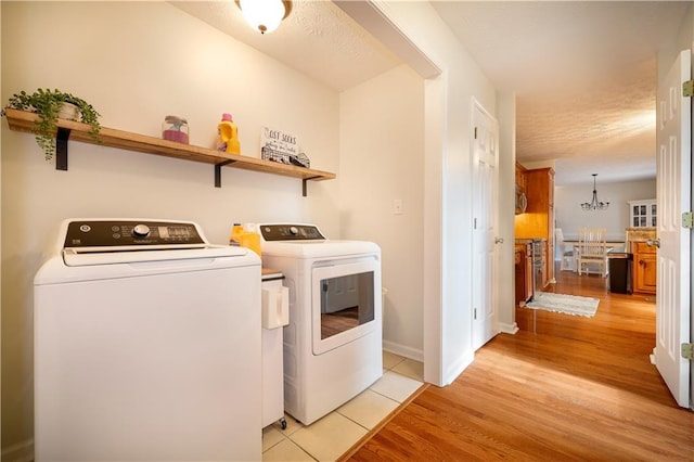 clothes washing area with laundry area, light wood-style flooring, baseboards, and independent washer and dryer