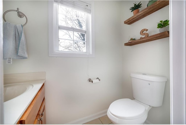 bathroom with baseboards, vanity, and toilet