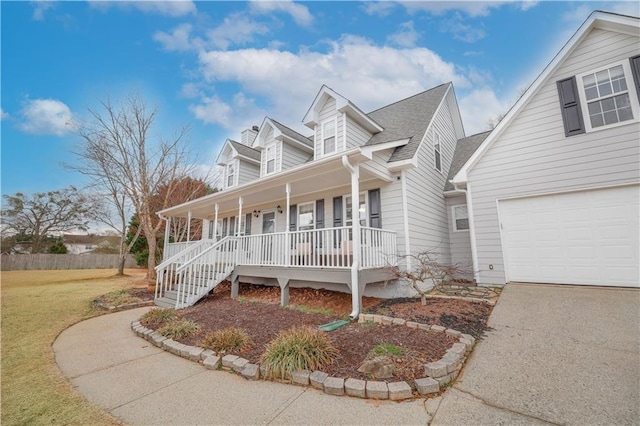 new england style home featuring a garage, driveway, a porch, and a front yard