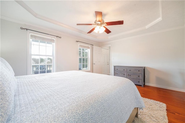 bedroom featuring ornamental molding, wood finished floors, and baseboards