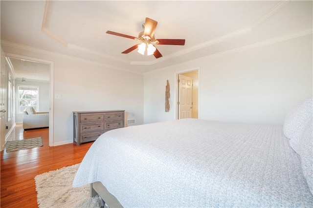 bedroom featuring a ceiling fan, baseboards, ornamental molding, and wood finished floors