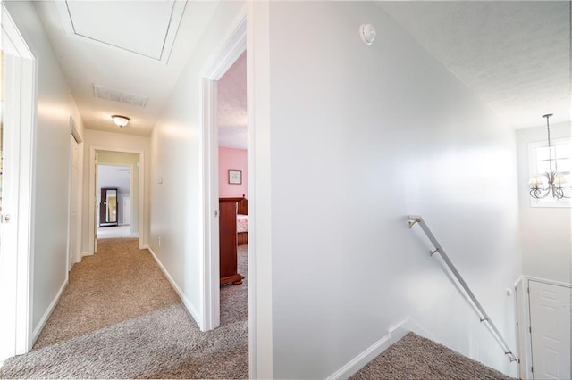 corridor with light carpet, baseboards, visible vents, and an upstairs landing