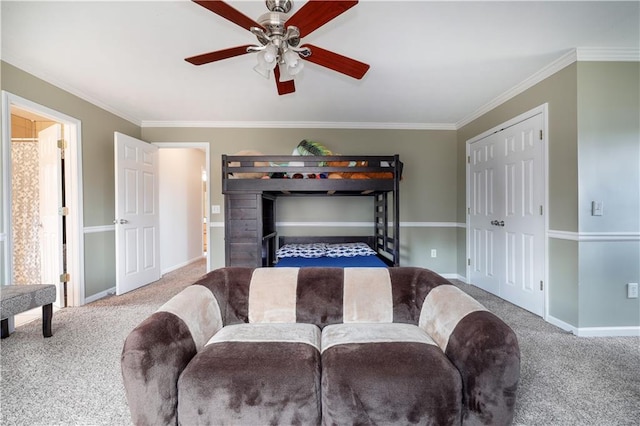 carpeted living area with a ceiling fan, crown molding, and baseboards