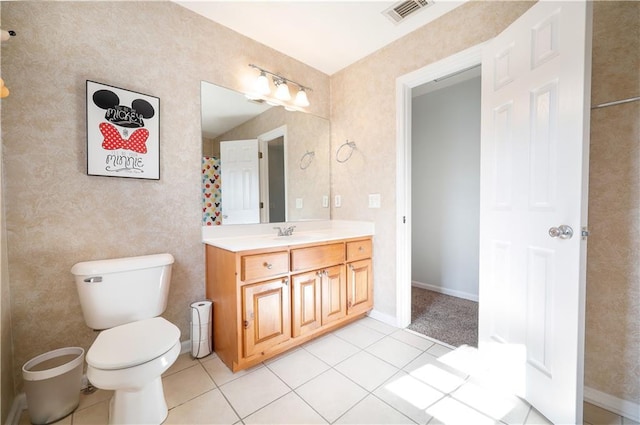 bathroom with toilet, vanity, baseboards, visible vents, and tile patterned floors