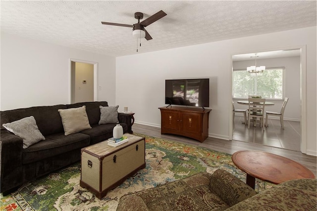 340 Monivea Ln, Roswell, GA 30075 - living room with ceiling fan, a chandelier, a textured ceiling, wood finished floors, and baseboards