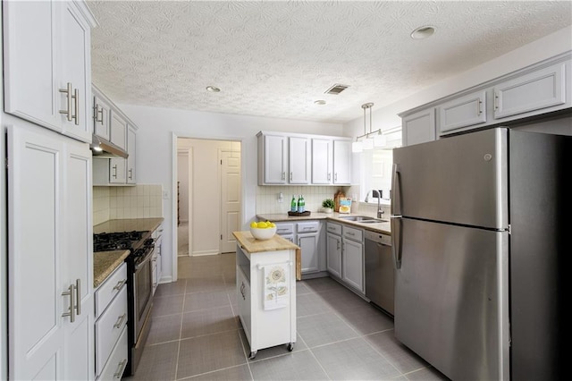 340 Monivea Ln, Roswell, GA 30075 - kitchen with appliances with stainless steel finishes, a sink, under cabinet range hood, tile patterned floors, and backsplash