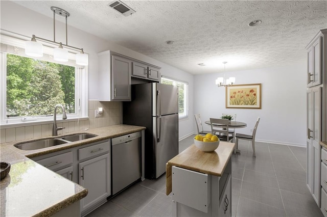 340 Monivea Ln, Roswell, GA 30075 - kitchen with appliances with stainless steel finishes, a sink, tasteful backsplash, gray cabinetry, and a chandelier