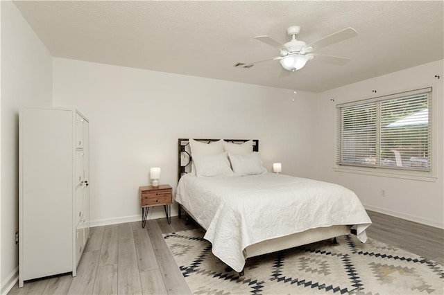 340 Monivea Ln, Roswell, GA 30075 - bedroom featuring light wood-type flooring, baseboards, a ceiling fan, and a textured ceiling