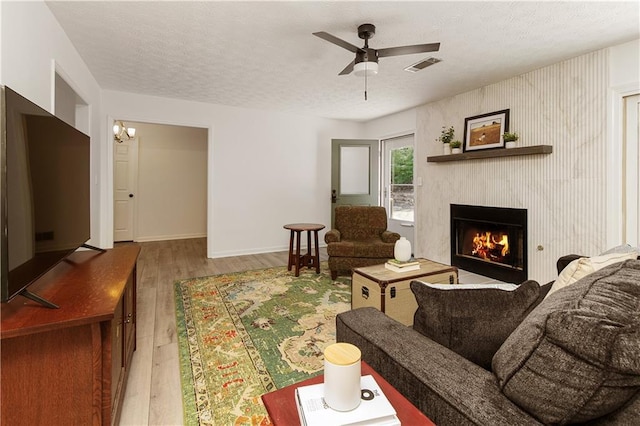 340 Monivea Ln, Roswell, GA 30075 - living room with wood finished floors, a fireplace, a textured ceiling, ceiling fan, and baseboards