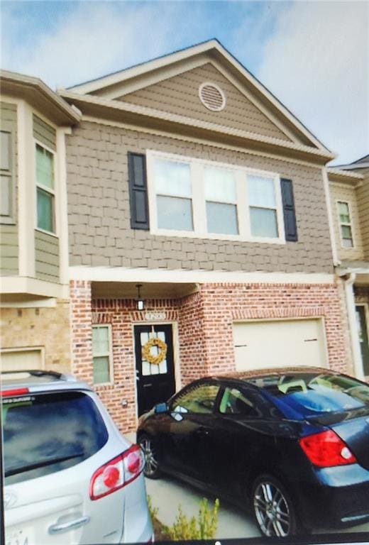 view of property with brick siding and an attached garage