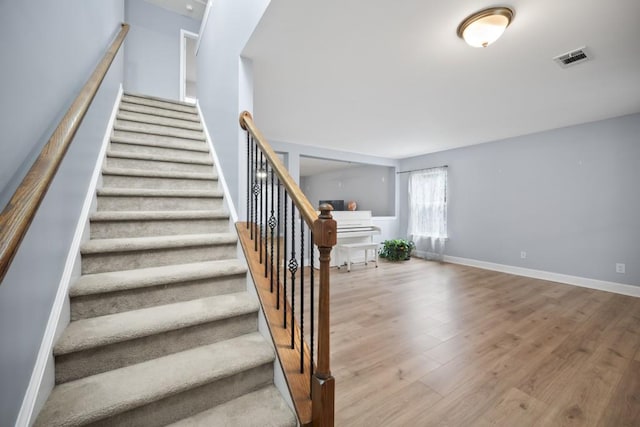 staircase with hardwood / wood-style floors