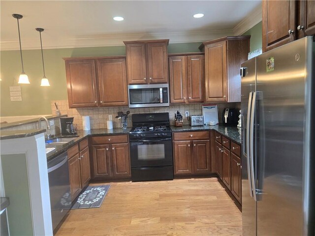106 Trailside Way, Hiram, GA 30141 - kitchen featuring appliances with stainless steel finishes, a sink, ornamental molding, a peninsula, and decorative light fixtures