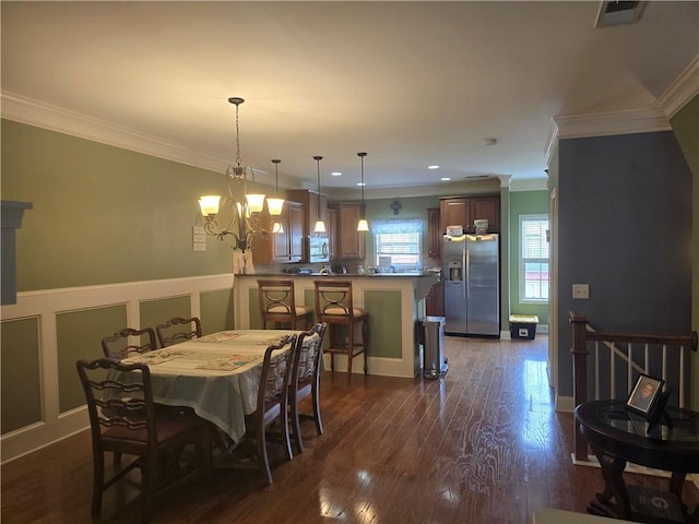 106 Trailside Way, Hiram, GA 30141 - dining space with crown molding, a chandelier, dark wood-style flooring, a wainscoted wall, and a decorative wall