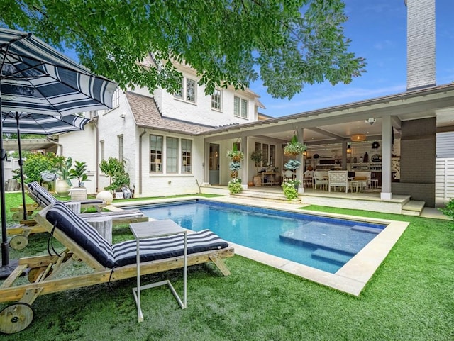 pool with a patio area and a lawn