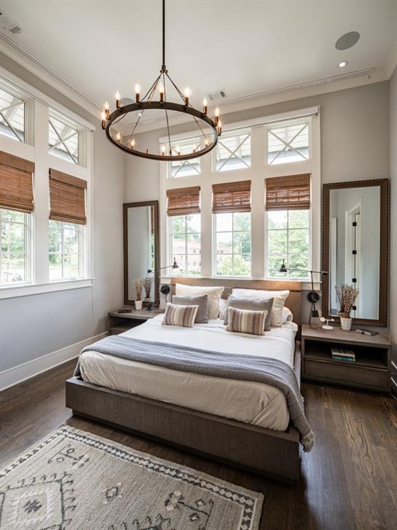 bedroom with baseboards, visible vents, dark wood finished floors, and crown molding