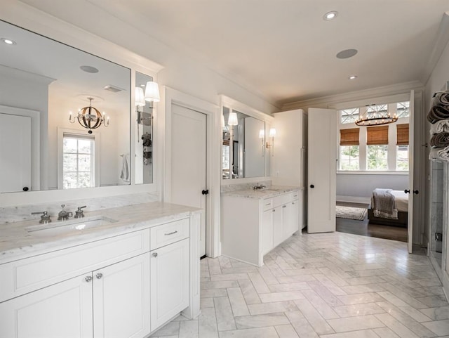 bathroom with ornamental molding, recessed lighting, two vanities, and a sink