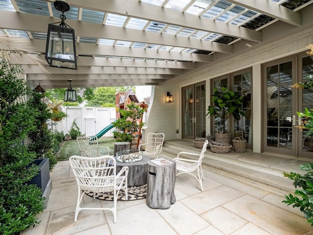 view of patio with outdoor dining space, fence, and a pergola