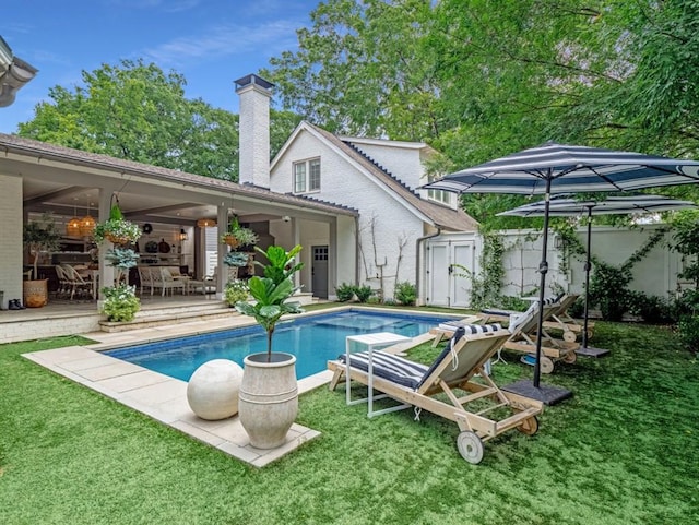 outdoor pool featuring a lawn