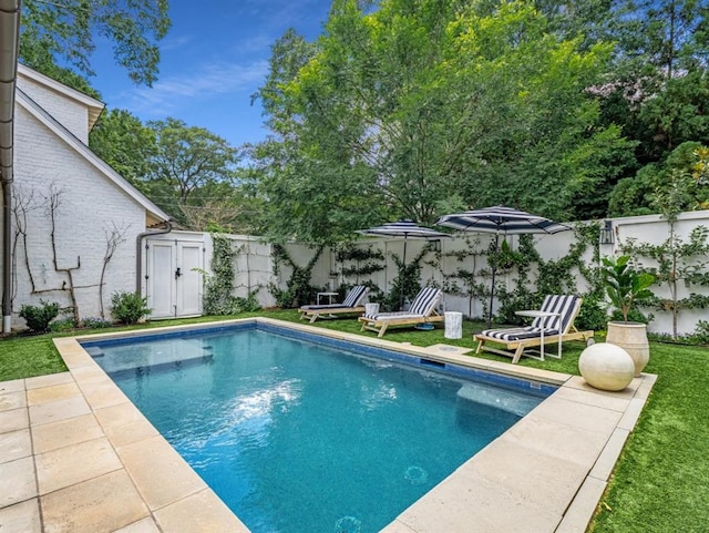 view of swimming pool featuring a fenced in pool, a fenced backyard, and a yard