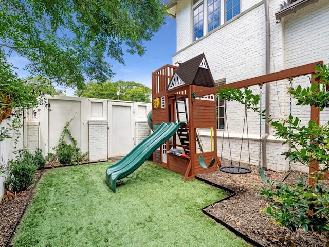 view of jungle gym featuring a lawn and a fenced backyard