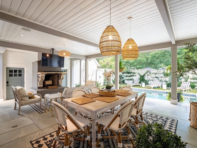 dining space featuring a wealth of natural light, a brick fireplace, and beam ceiling