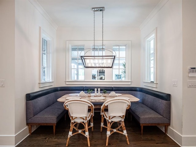 dining room with breakfast area, crown molding, baseboards, and wood finished floors