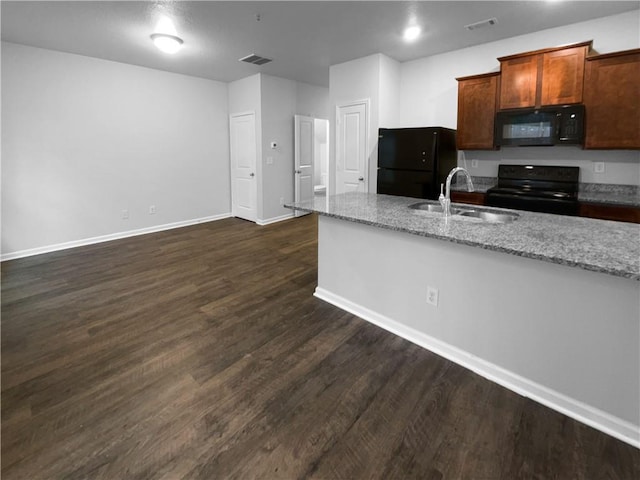 kitchen with a sink, visible vents, light stone countertops, dark wood-style floors, and black appliances