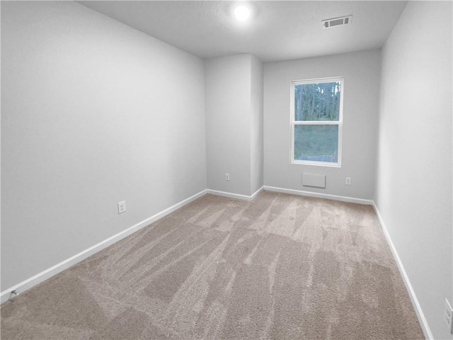 spare room with light carpet, baseboards, and visible vents