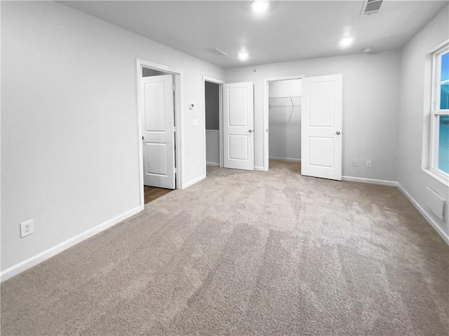 unfurnished bedroom featuring carpet floors, recessed lighting, a closet, visible vents, and baseboards