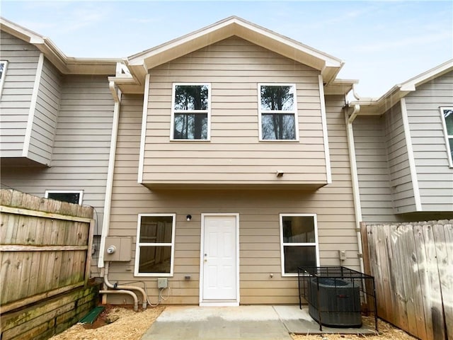 rear view of house with a patio, cooling unit, and a fenced backyard