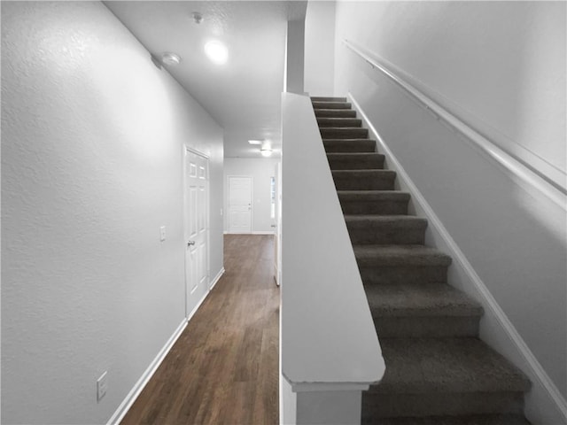 stairs featuring wood finished floors and baseboards