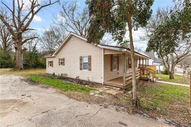 view of side of home featuring covered porch