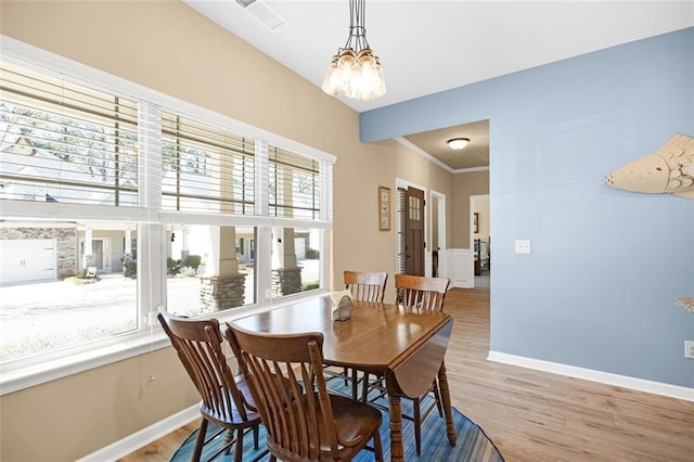 staircase with visible vents, ornamental molding, wainscoting, a decorative wall, and wood finished floors