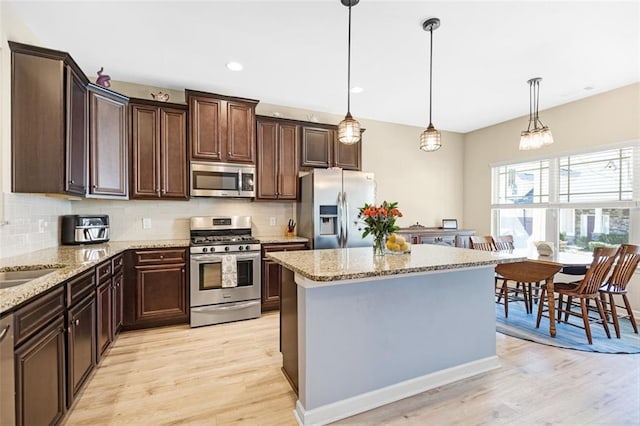 dining room with baseboards, wood finished floors, and a healthy amount of sunlight