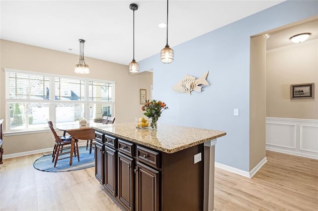 kitchen with light wood-type flooring, dark brown cabinetry, tasteful backsplash, and stainless steel appliances
