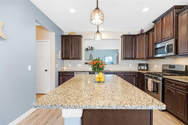 kitchen featuring light wood-style floors, decorative backsplash, and dark brown cabinetry