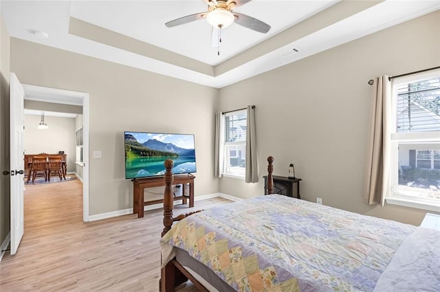 living area featuring ceiling fan, a stone fireplace, visible vents, baseboards, and light wood-style flooring