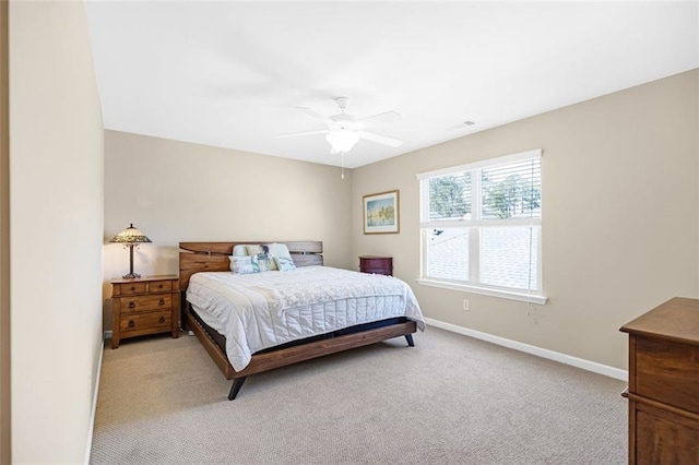 bedroom featuring baseboards, light wood finished floors, a tray ceiling, and visible vents