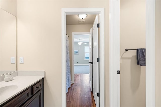 bathroom with vanity, a bath, a stall shower, and wood finished floors