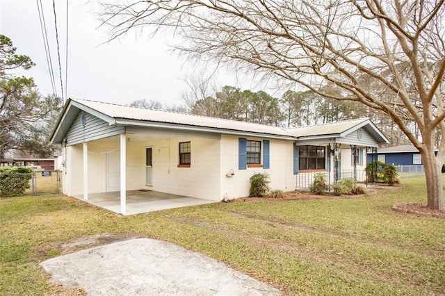 single story home featuring a front yard, metal roof, fence, a carport, and driveway