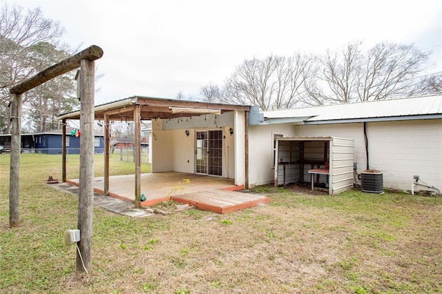 back of house with metal roof, a lawn, and cooling unit