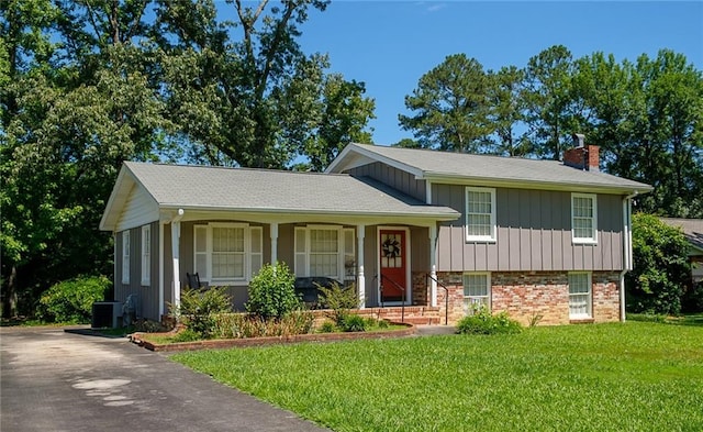 split level home featuring central air condition unit and a front lawn