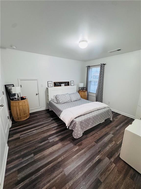 bedroom with dark hardwood / wood-style flooring