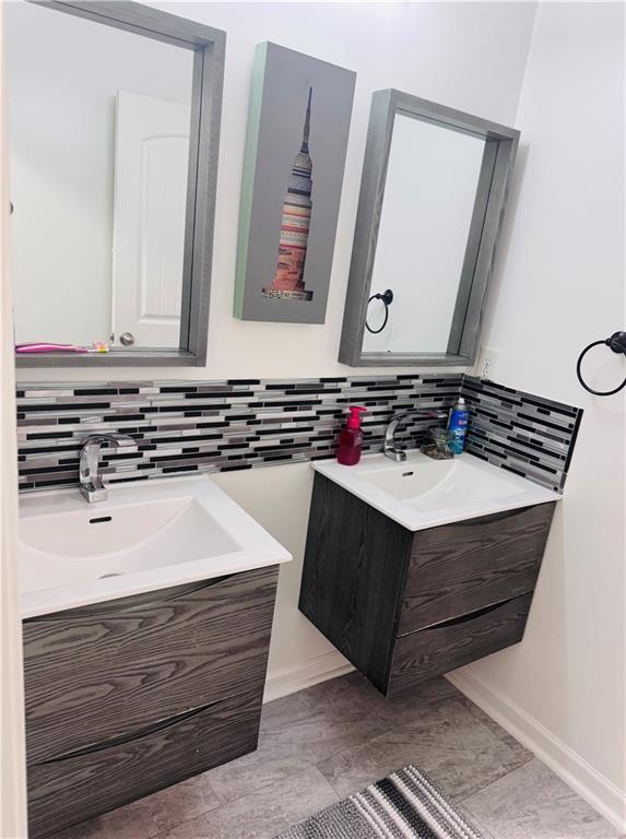 bathroom with tasteful backsplash and vanity