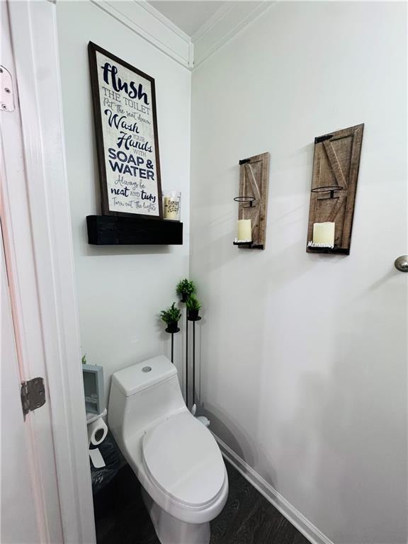 bathroom with crown molding and toilet