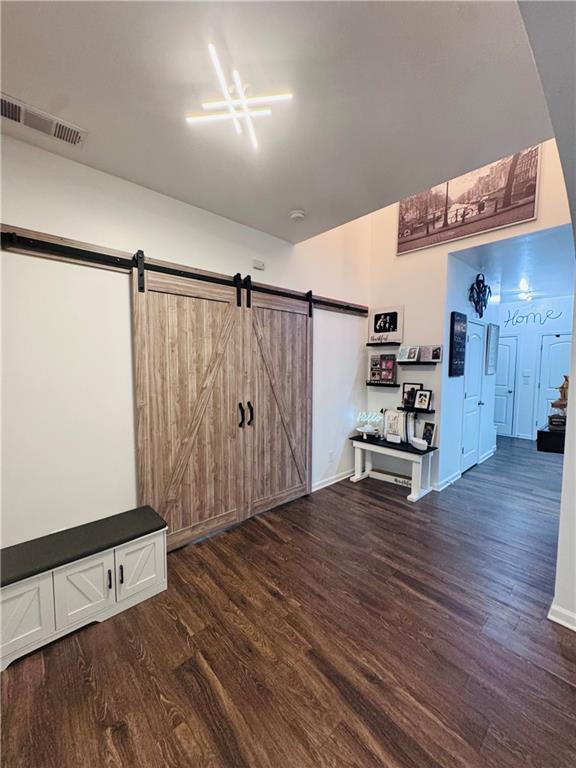 interior space featuring dark wood-type flooring and a barn door