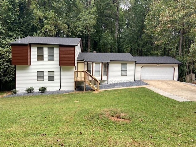 split level home with an attached garage, concrete driveway, and a front yard