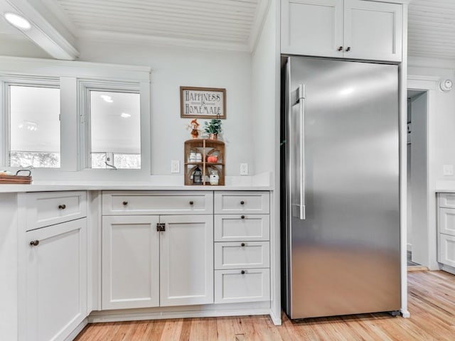 kitchen featuring high end refrigerator, light wood-type flooring, and white cabinetry